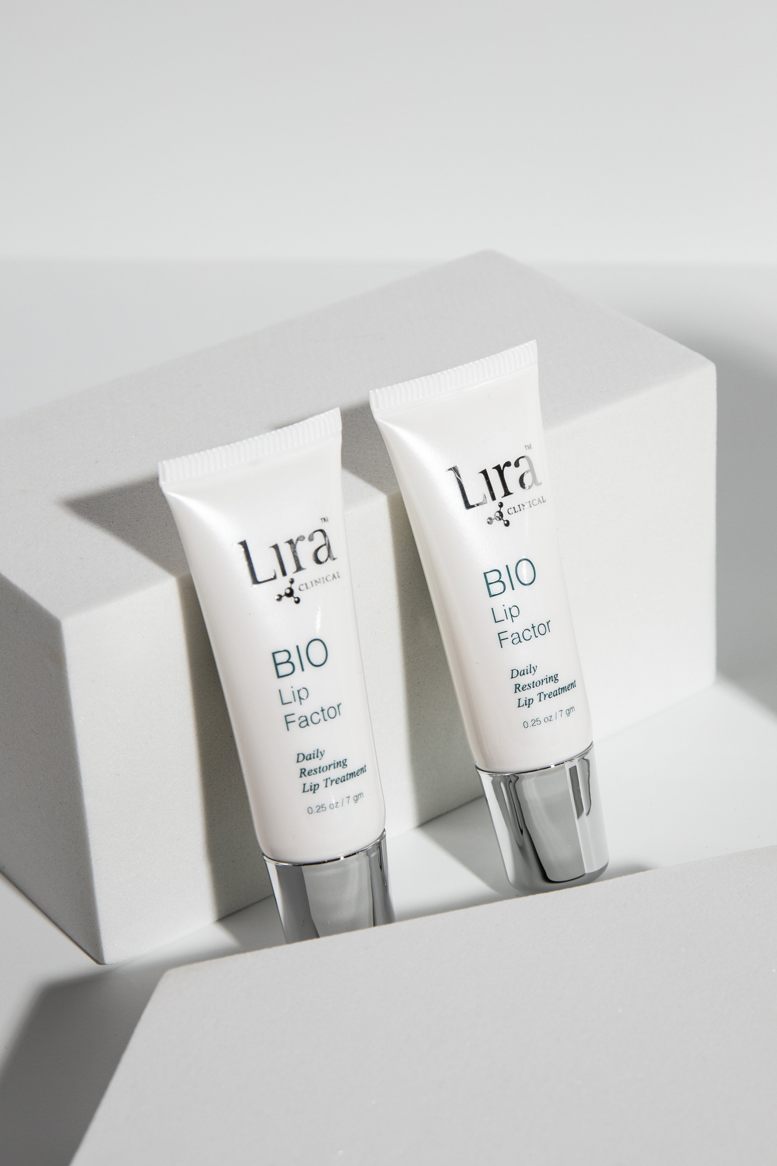 Lira Clinical Bio lip Factor tube vertically lying on grey background