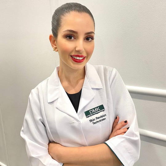 Image of one the skin consultants in Australian Beauty Clinic smiling with a hair bun and red lipstick
