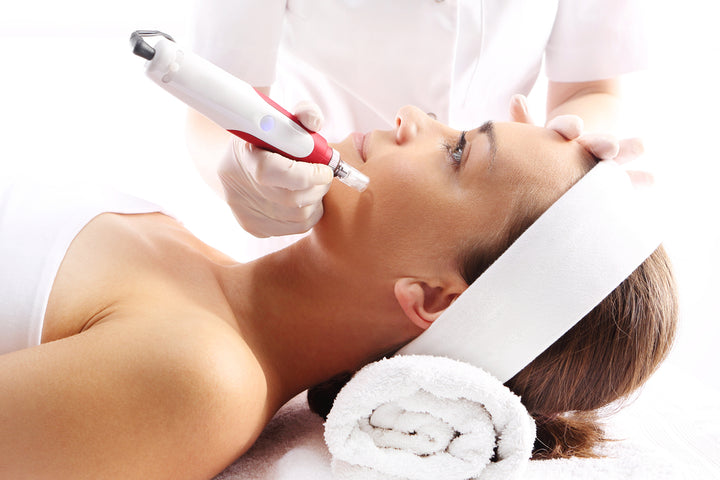 A beautiful lady getting micro needling done on her face by a professional